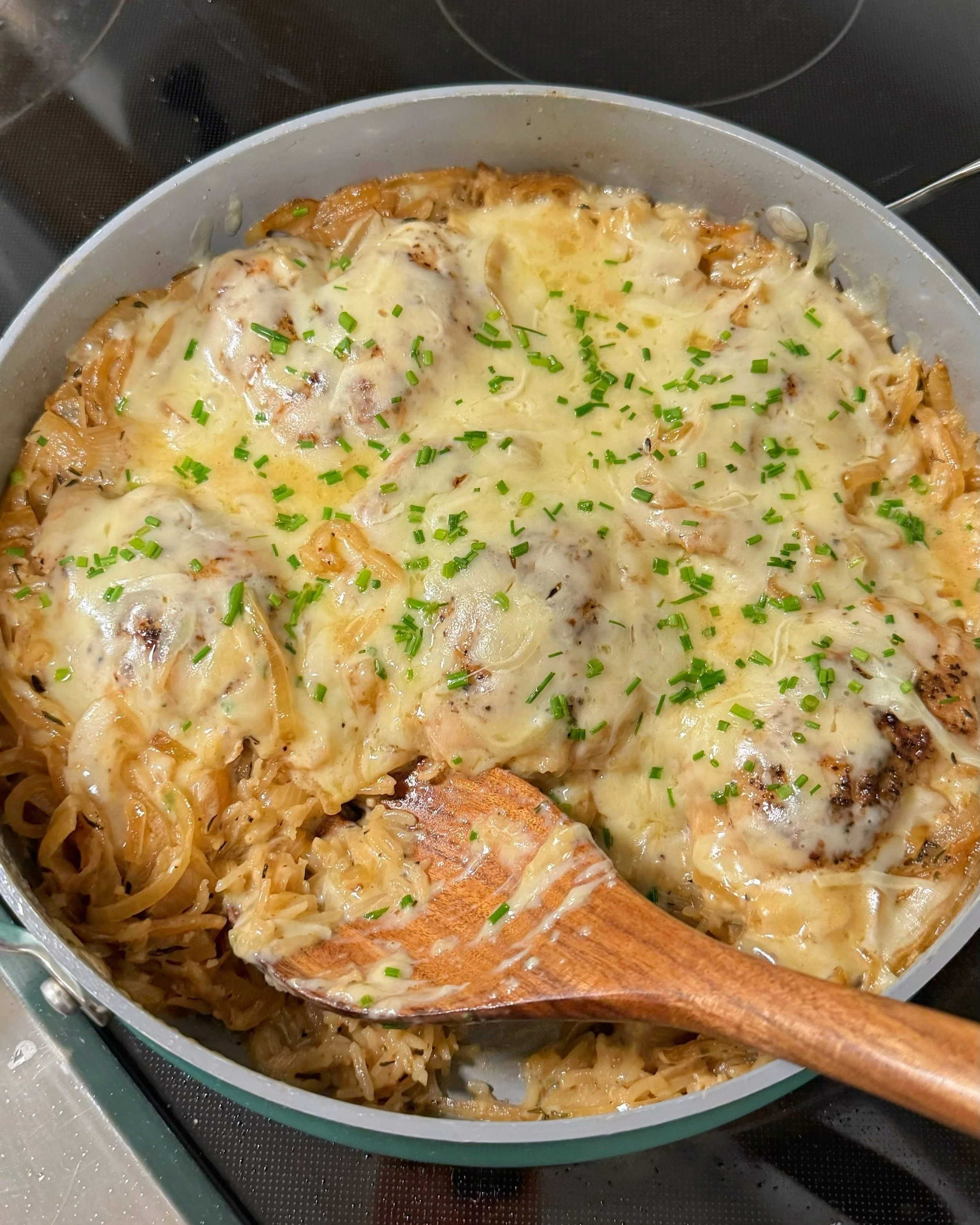 A pan of french onion chicken and rice with chopped chives sprinkled on top.