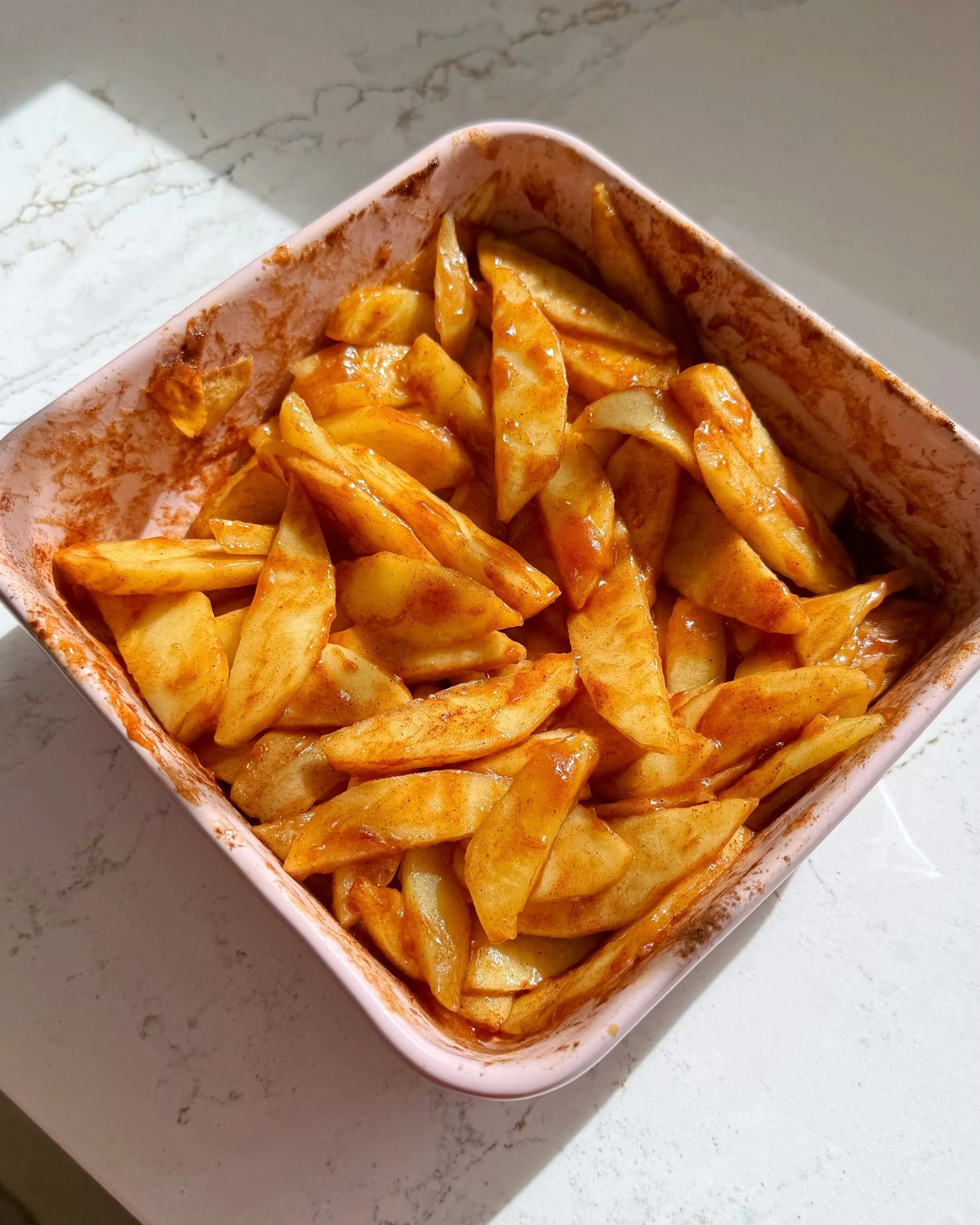 A baking dish with maple cinnamon baked apples.