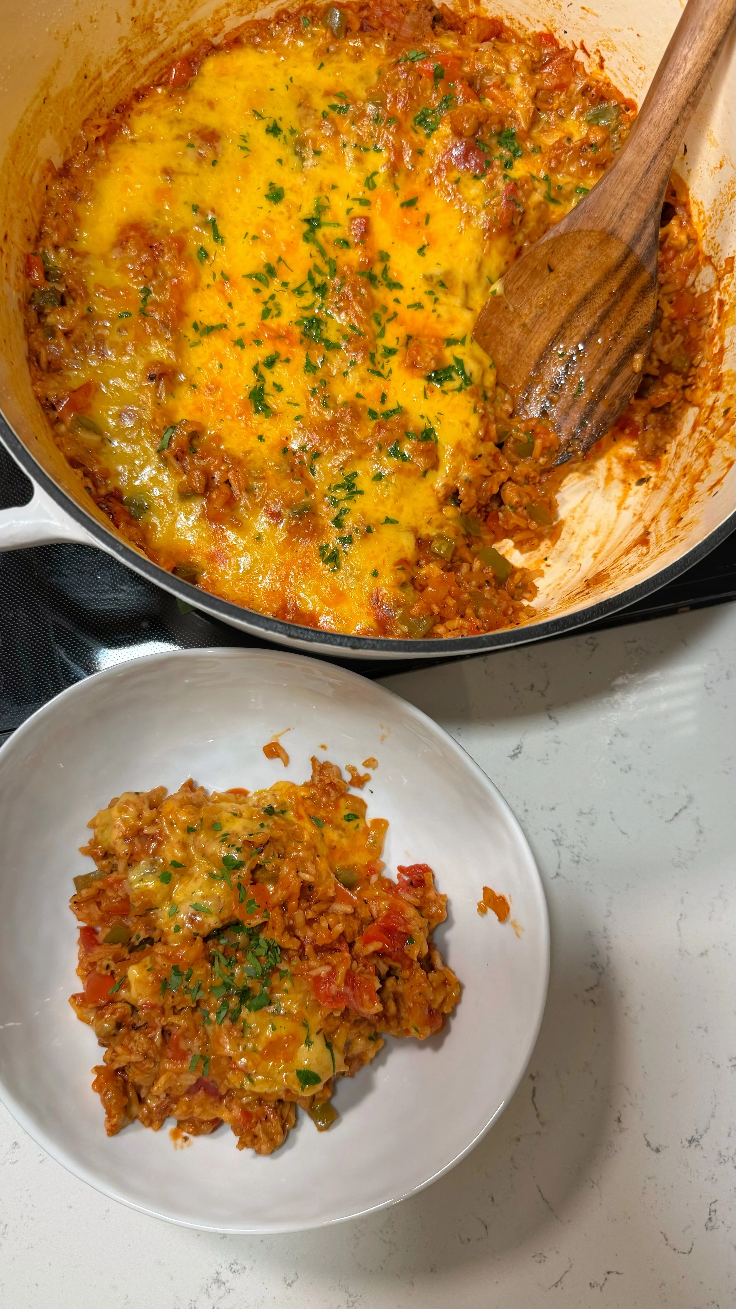 A pot of cooked ground Italian chicken, bell peppers & onion in a tomato chicken stock base. Topped with fresh parsley.