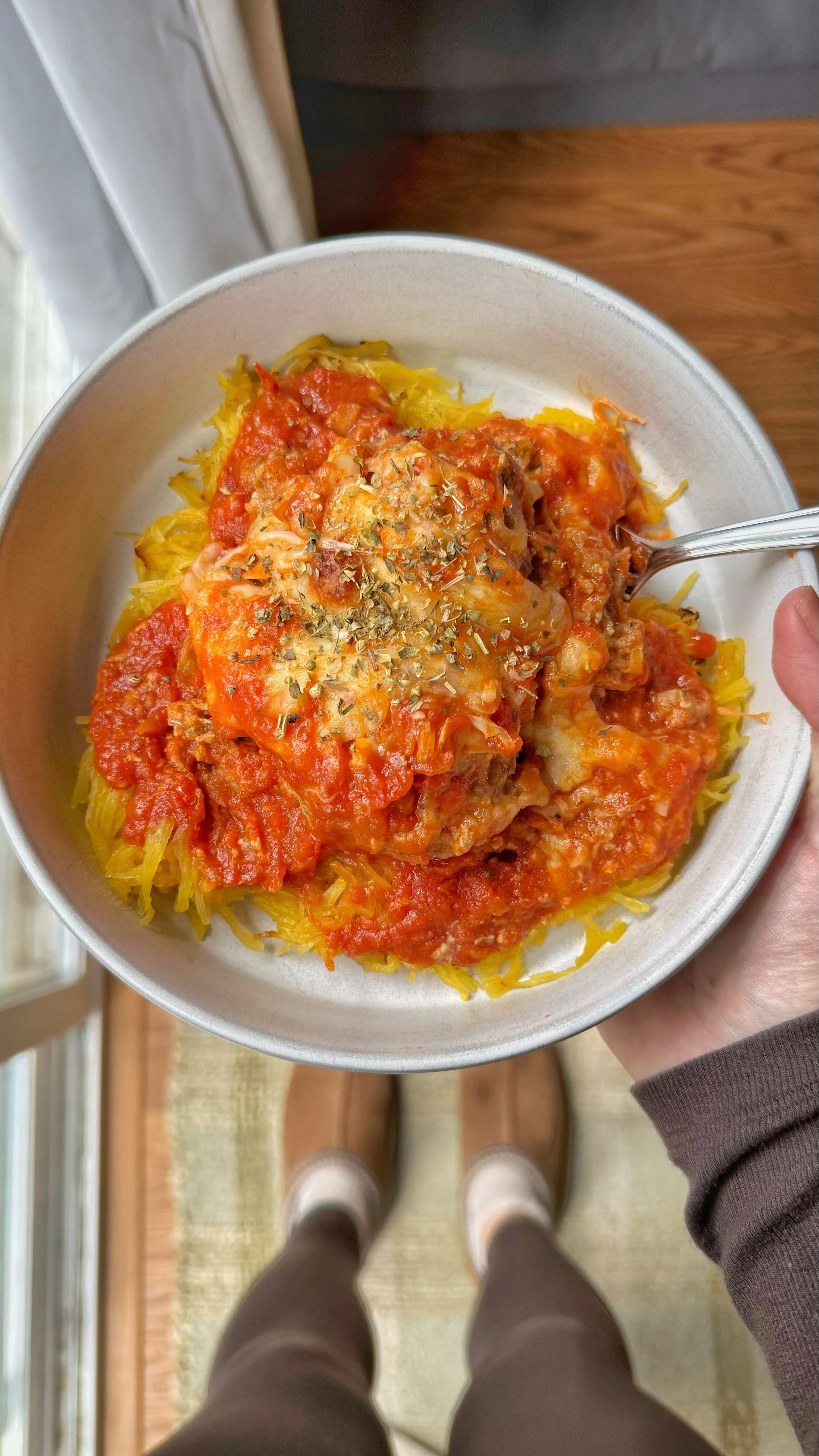 A bowl of meatballs with pasta sauce on a bed of spaghetti squash.