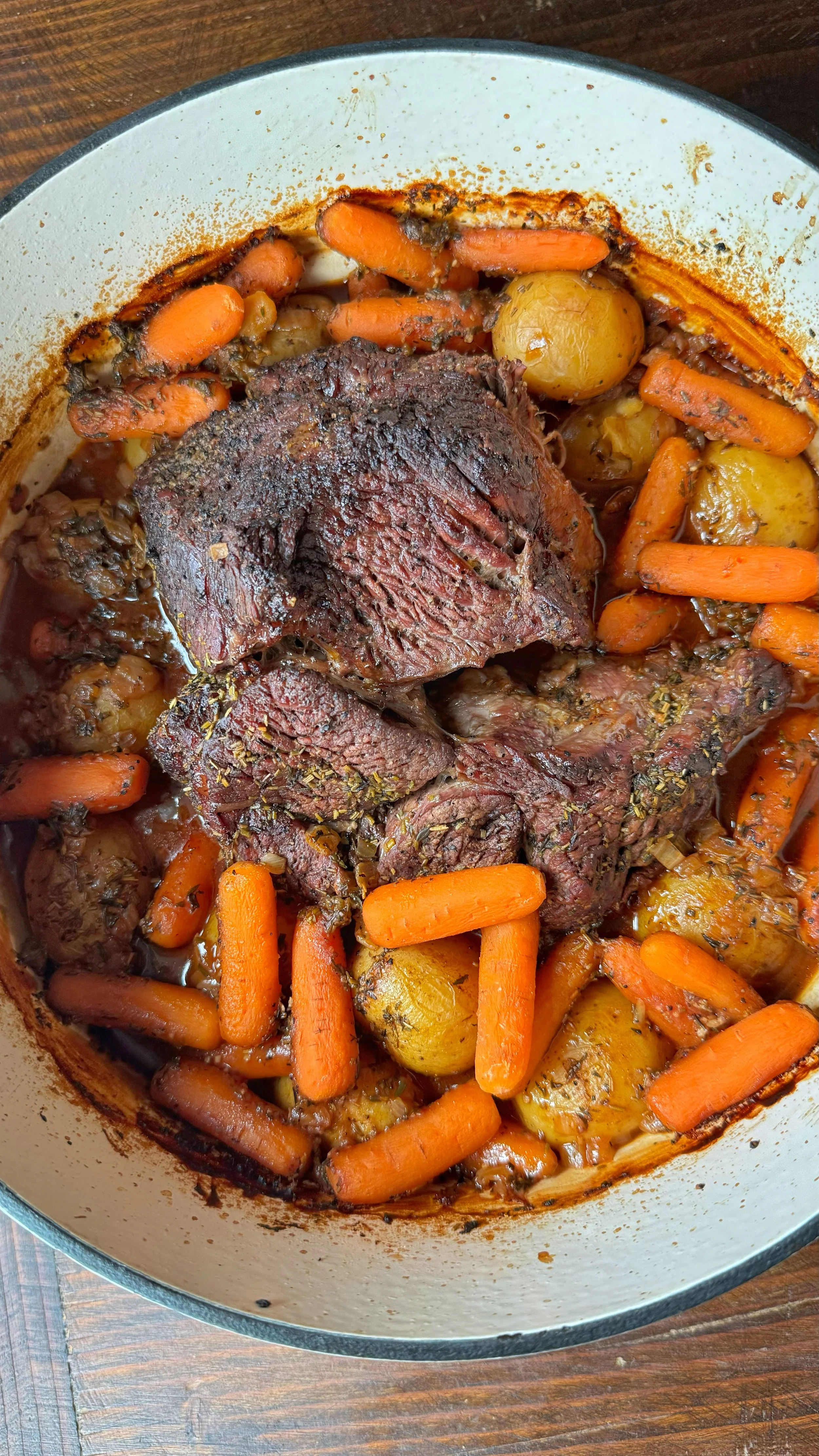 A pot of roast, potatoes and carrots.